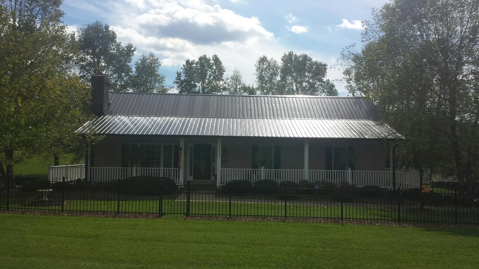 Gray metal roof on a brick ranch with a full width front porch — Gutter Guard Installation work by our crew in Wildomar